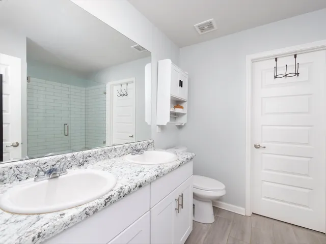 a bathroom with a granite countertop sink toilet a large mirror and shower