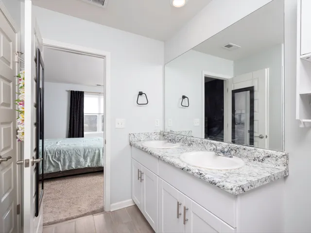 a en suite bathroom with a granite countertop sink and a mirror