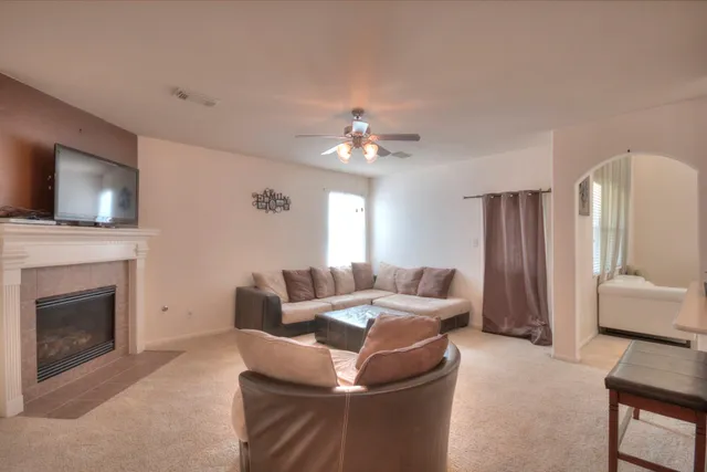 a living room with furniture a fireplace and a flat screen tv