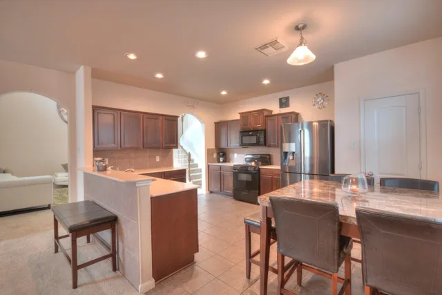 a kitchen with a sink a counter top space stainless steel appliances and cabinets