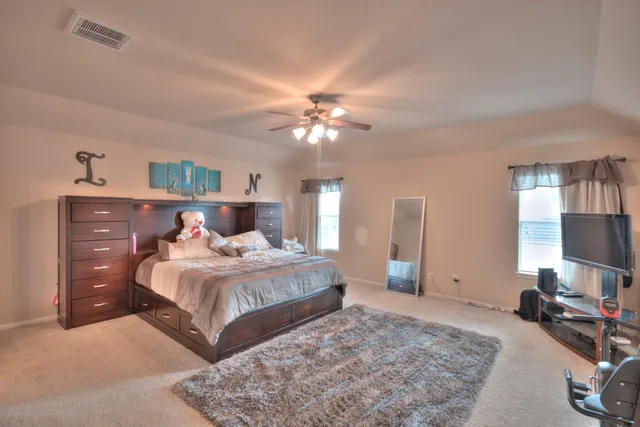 a bedroom with a large bed and a chandelier
