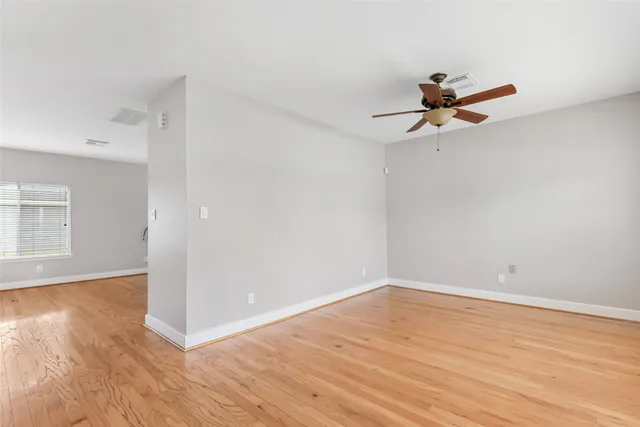 a view of a room with wooden floor and ceiling fan