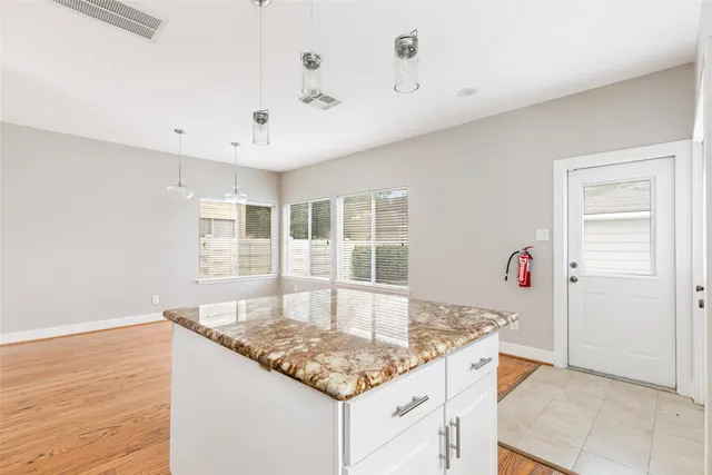 a kitchen with granite countertop sink and natural light