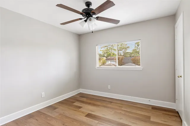 an empty room with a window and a fan