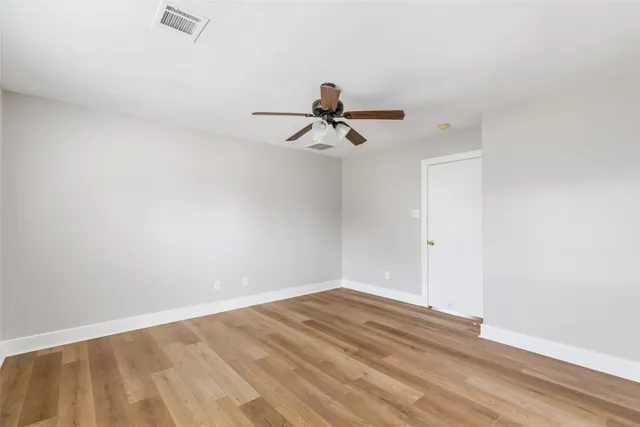 a view of a room with wooden floor and a ceiling fan