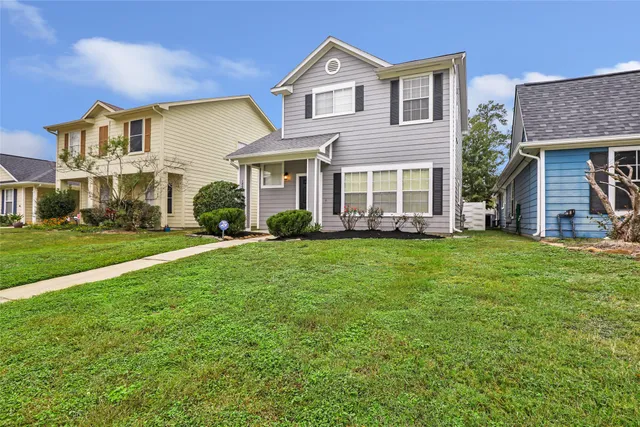 a front view of a house with a yard and trees