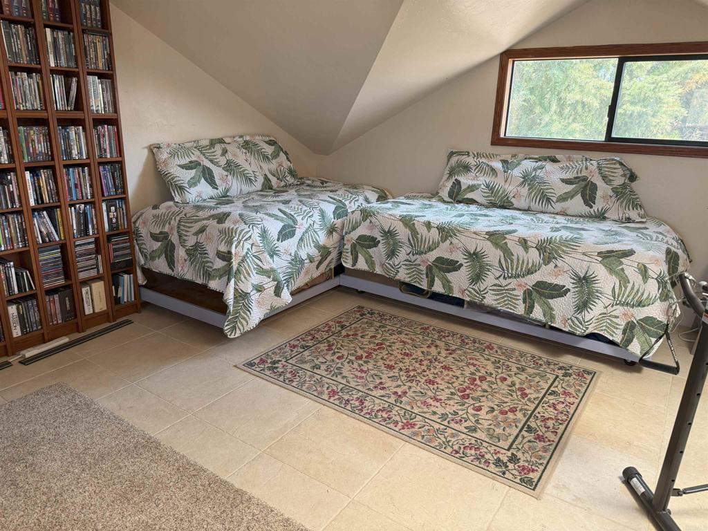 12993 Old Barona Road Lakeside, CA 92040 - Photo 15 of 48 a bed sitting in a bedroom next to a book shelf