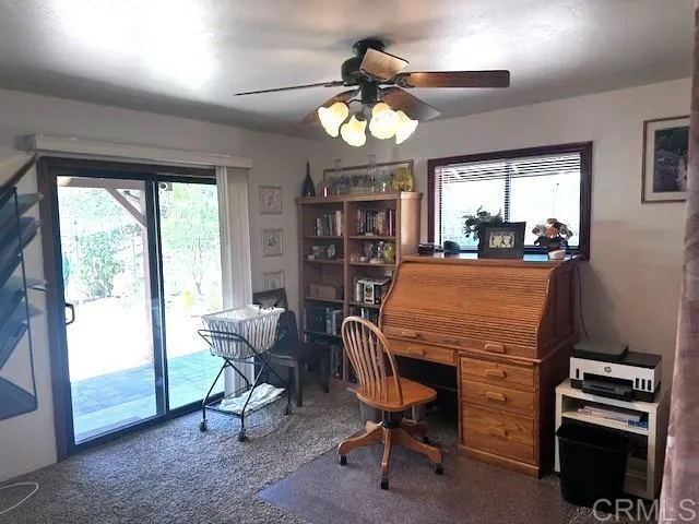 a view of a workspace with furniture and a window