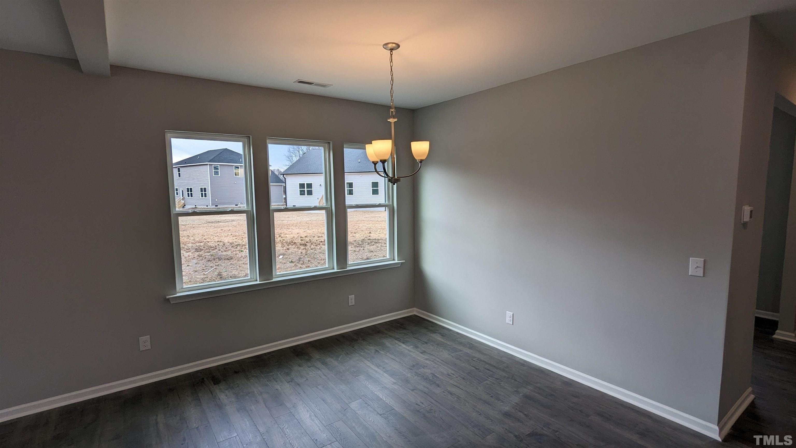 32 Daffodil Garden Court Smithfield, NC 27577 - Photo 3 of 19 a view of an empty room with wooden floor and a window