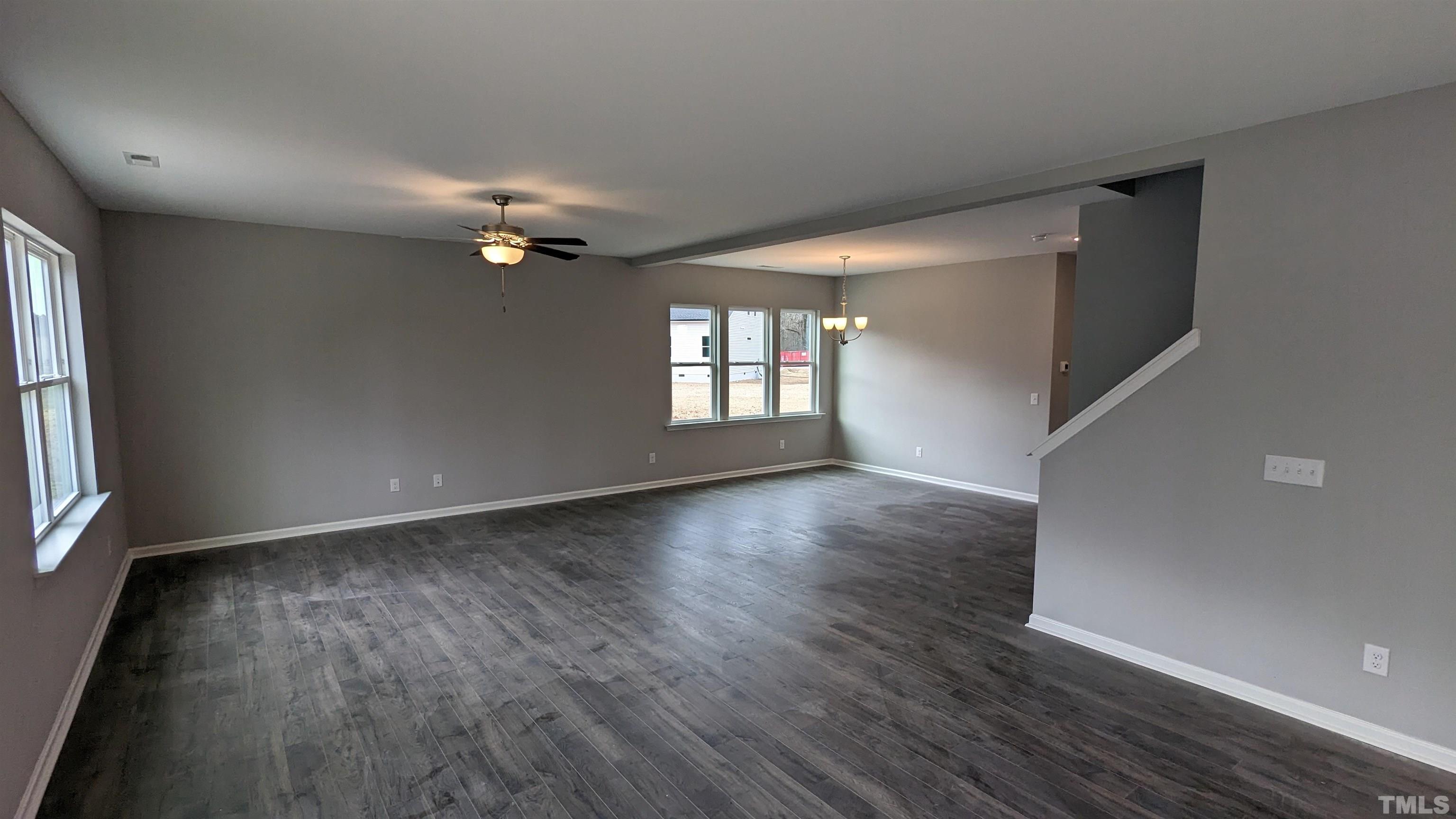 32 Daffodil Garden Court Smithfield, NC 27577 - Photo 4 of 19 an empty room with wooden floor and windows