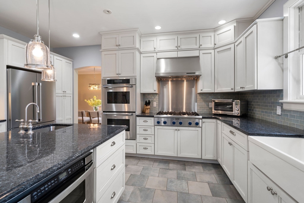 45 Sherman's Bridge Road Wayland, MA 01778 - Photo 11 of 20 a kitchen with stainless steel appliances granite countertop a sink refrigerator stove and microwave