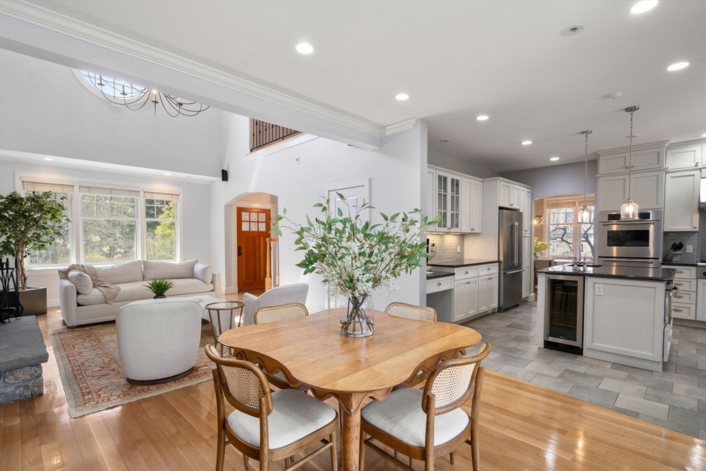 45 Sherman's Bridge Road Wayland, MA 01778 - Photo 9 of 20 a kitchen with a refrigerator and a dining table with wooden floor