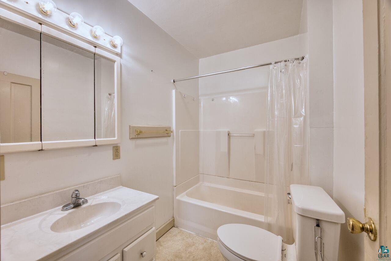 4191 Kerr Location Hibbing, MN 55746 - Photo 11 of 37 Bathroom with toilet, vanity, and shower / tub combo