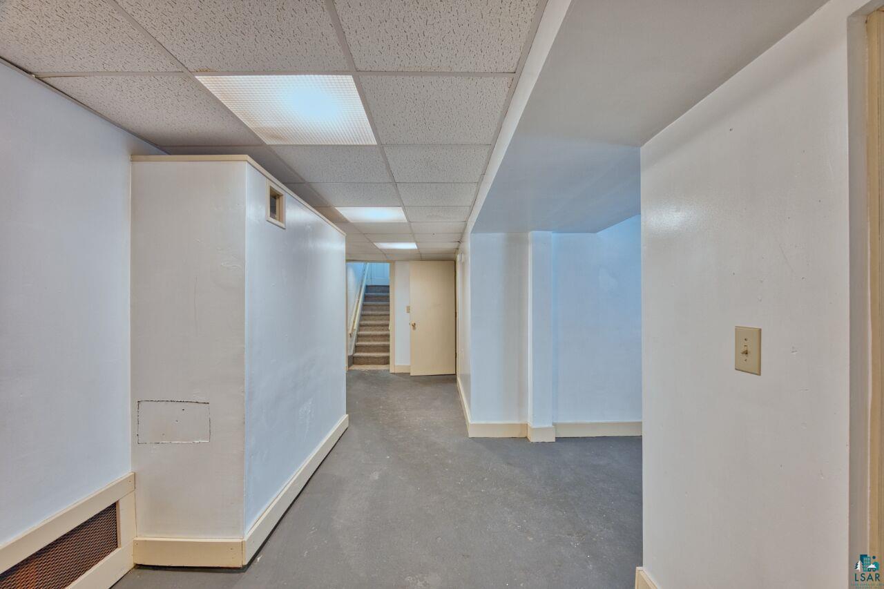 4191 Kerr Location Hibbing, MN 55746 - Photo 16 of 37 Corridor with a drop ceiling, concrete floors, stairs, and baseboards