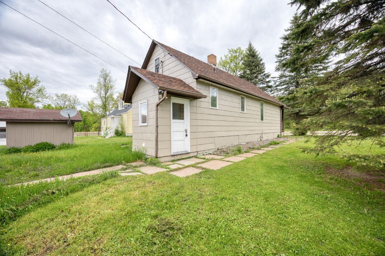 4191 Kerr Location Hibbing, MN 55746 - Photo 28 of 37 Back of house with a yard, a chimney, and roof with shingles