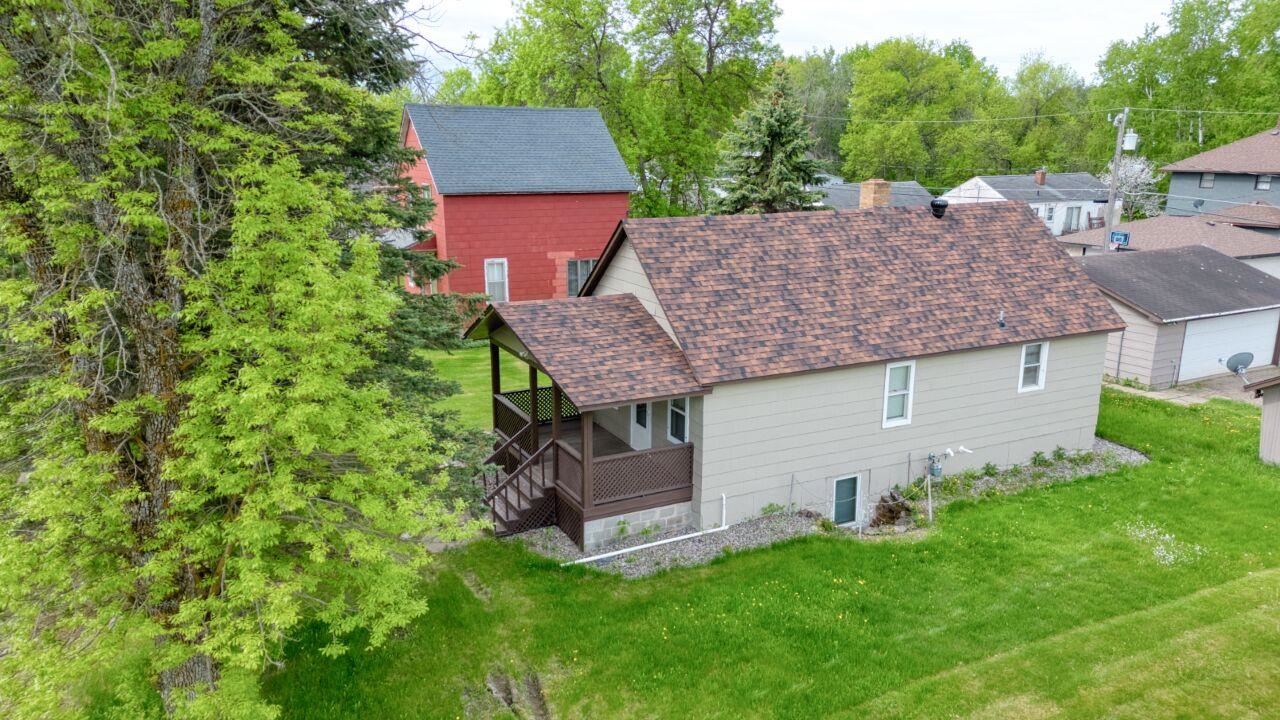 4191 Kerr Location Hibbing, MN 55746 - Photo 31 of 37 Rear view of house featuring a shingled roof and a lawn