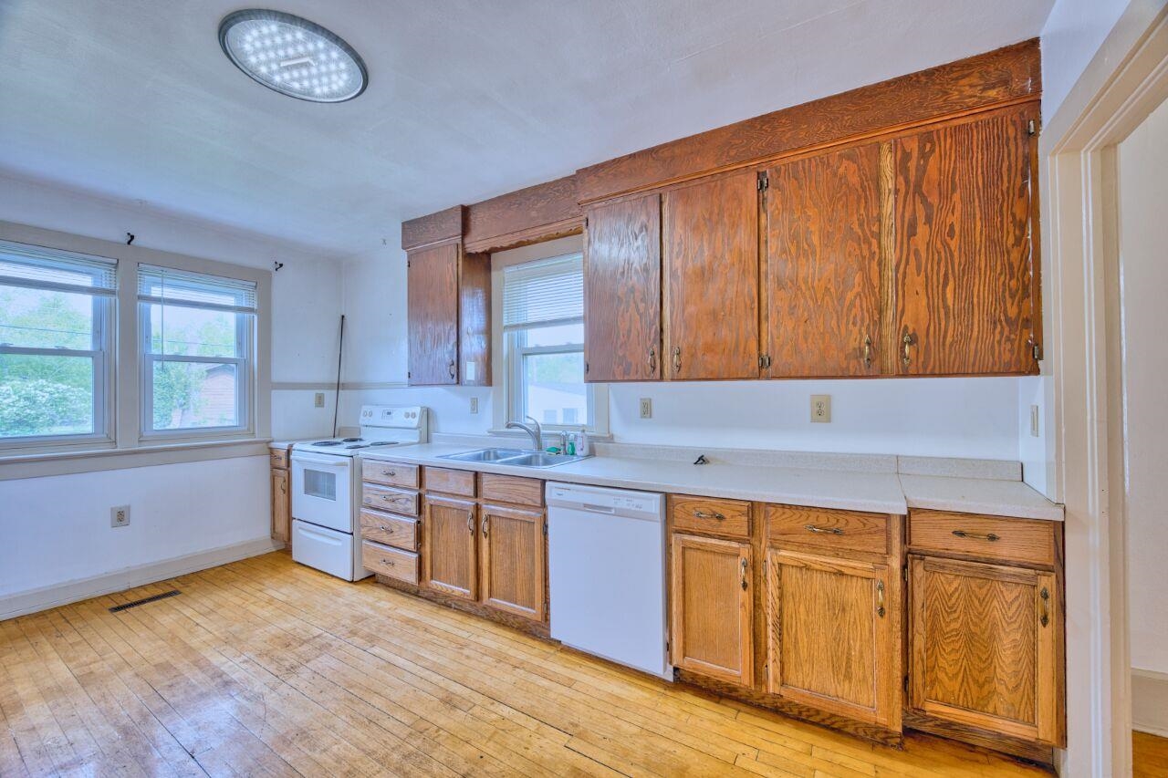 4191 Kerr Location Hibbing, MN 55746 - Photo 5 of 37 Kitchen with white appliances, a sink, light wood-style flooring, and light countertops