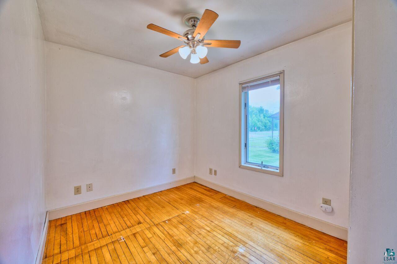 4191 Kerr Location Hibbing, MN 55746 - Photo 9 of 37 Unfurnished room featuring baseboards, ceiling fan, and light wood-style floors