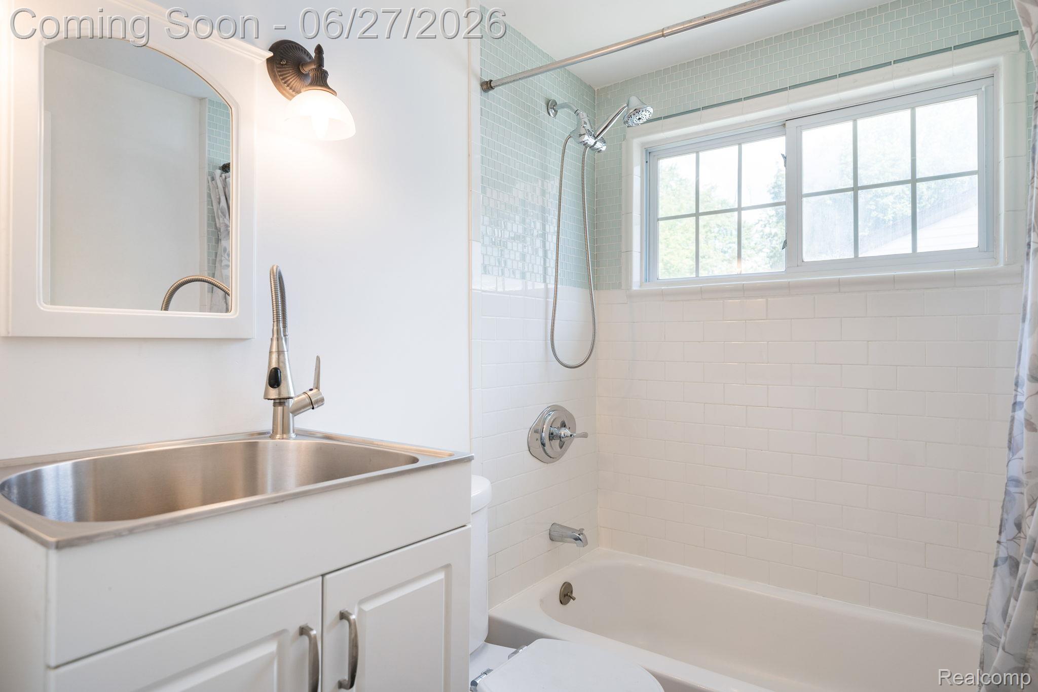 39 Mohawk Road Pontiac, MI 48341 - Photo 25 of 32 Bathroom featuring a white vanity with a stainless steel sink, brushed nickel faucet, and an arched mirror