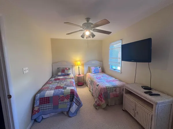 a bedroom with two beds and a flat screen tv