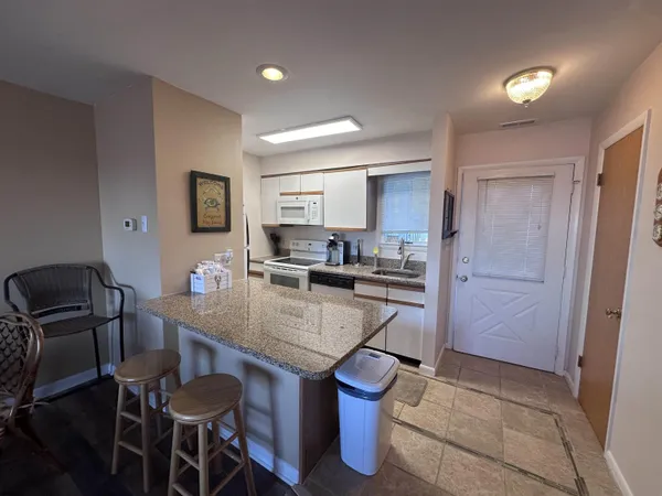 a kitchen with a dining table chairs and refrigerator
