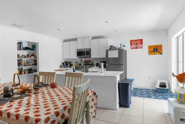 a living room with a couch and a dining table with wooden floor