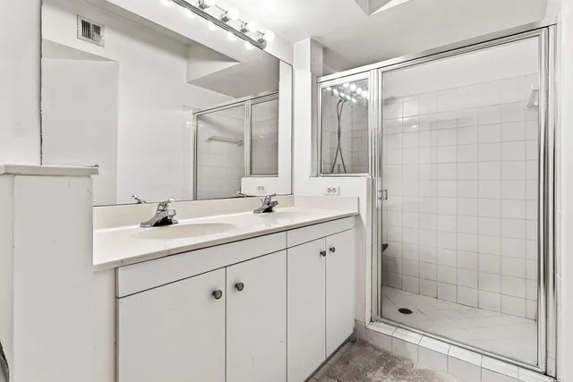 a bathroom with a shower sink and mirror