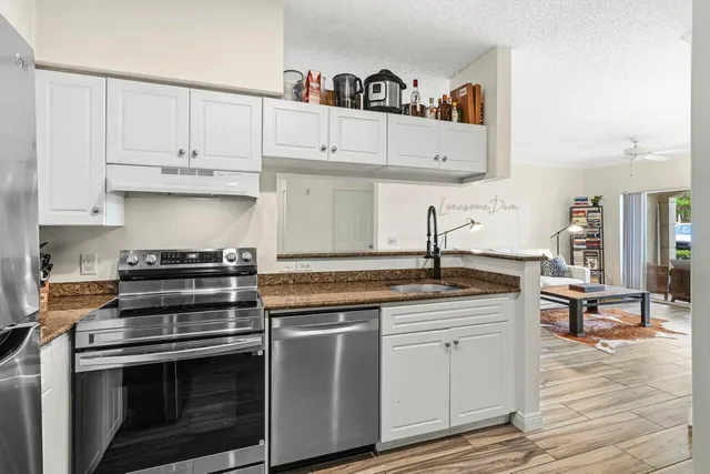 a kitchen with white cabinets and appliances