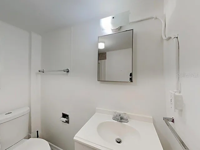 a bathroom with a sink a toilet and mirror