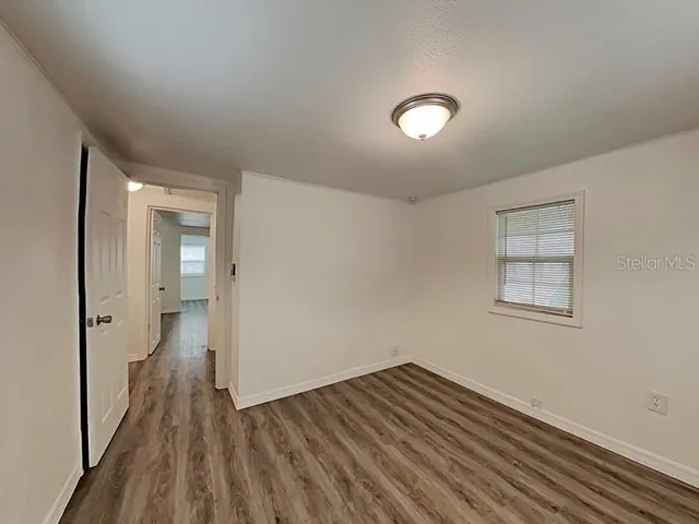 wooden floor in an empty room with a window