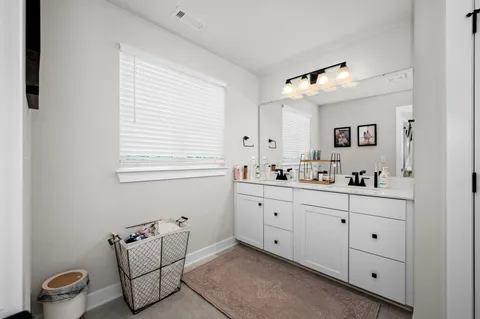 a spacious bathroom with a double vanity sink and a window