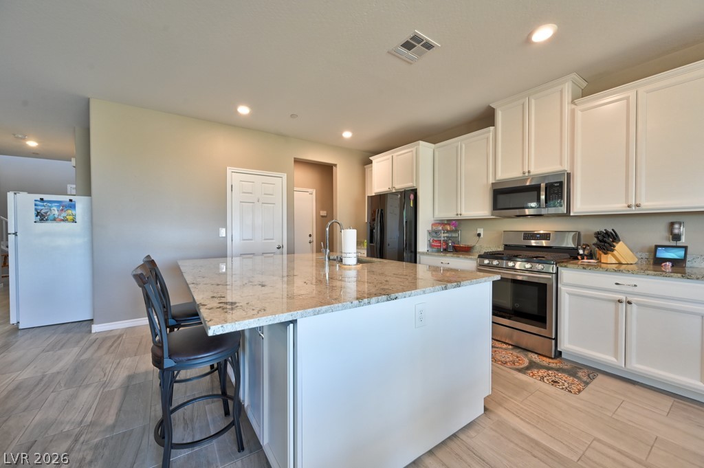 1054 Langston Ranch Avenue Henderson, NV 89002 - Photo 20 of 82 Kitchen additional view and door to walk in pantry. Seating at island. Gigantic island perfect to bake goods. Convenient sink. Recessed lighting. Alcove leads out to garage and to the right the casita has an additional door entrance into the house.