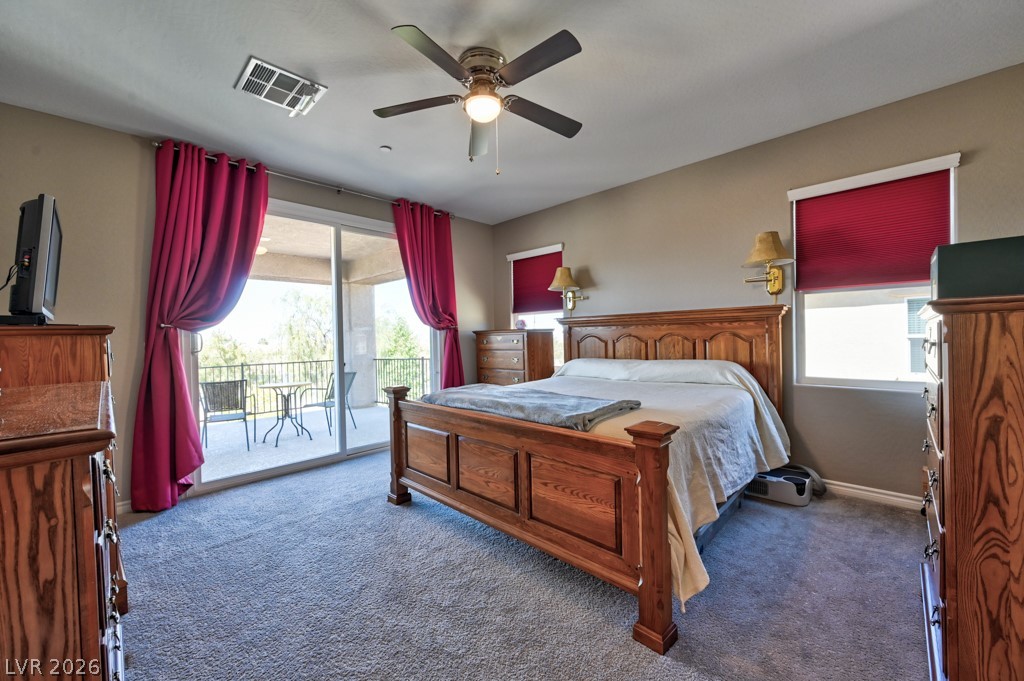 1054 Langston Ranch Avenue Henderson, NV 89002 - Photo 52 of 82 MAIN PRIMARY BEDROOM featuring access to exterior BALCONY WITH PARTIAL STRIP VIEWS AND CITY VIEWS AND MOUNTAIN VIEWS. Carpet and a lighted ceiling fan. Large walk in closet entered through bathroom.