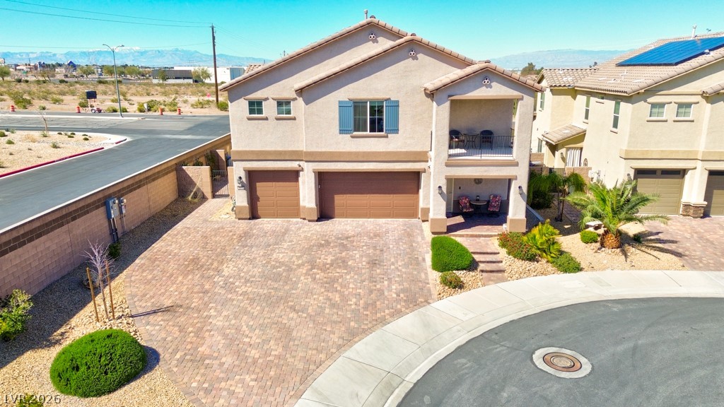 1054 Langston Ranch Avenue Henderson, NV 89002 - Photo 6 of 82 Mediterranean / spanish-style home featuring a balcony, an attached garage, a mountain view, stucco siding, and decorative driveway that fits up to 7 cars. No neighbors to the West of home. Only one neighbor on the East side.