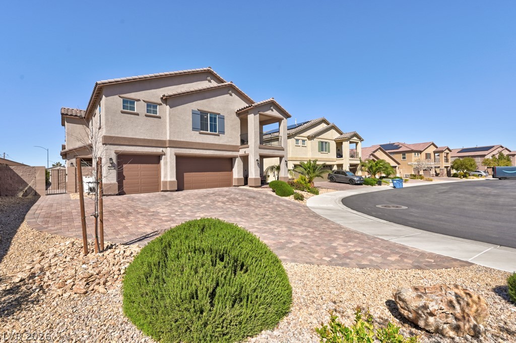 1054 Langston Ranch Avenue Henderson, NV 89002 - Photo 8 of 82 Mediterranean style house with a garage, stucco siding, a gate to Multi-generational casita , driveway, and a residential view