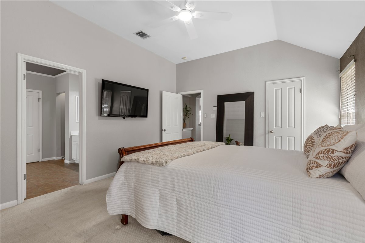 9012 Meacham Way Austin, TX 78749 - Photo 17 of 34 Carpeted bedroom featuring vaulted ceilings, a ceiling fan, and light gray painted walls