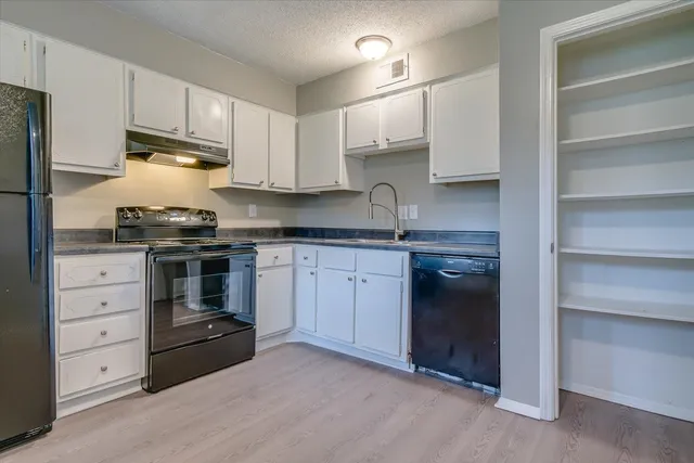 a kitchen with cabinets stainless steel appliances and a counter space