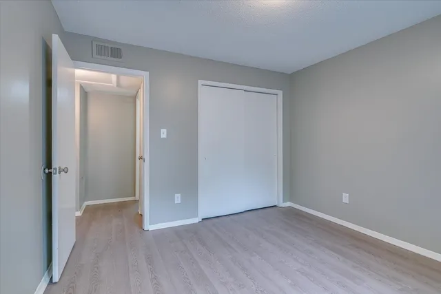 a view of an empty room with closet and a window