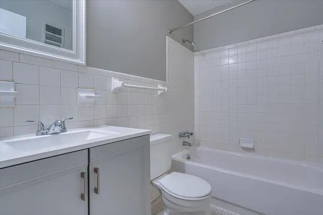 a bathroom with a sink toilet vanity and shower