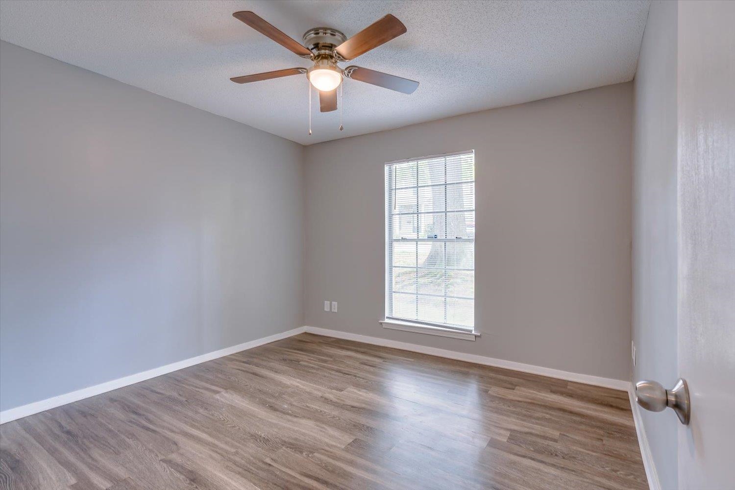 3636 Spottswood Avenue, Unit 1 Memphis, TN 38111 - Photo 23 of 32 an empty room with wooden floor ceiling fan and windows