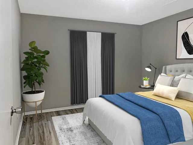 a bedroom with a bed and a potted plant