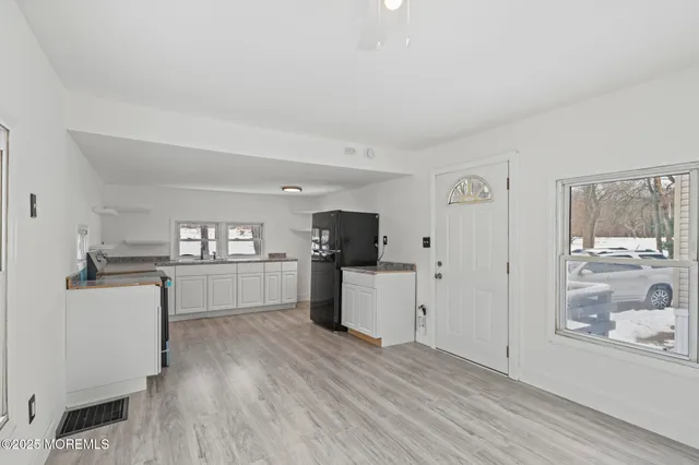 a kitchen with white cabinets and window