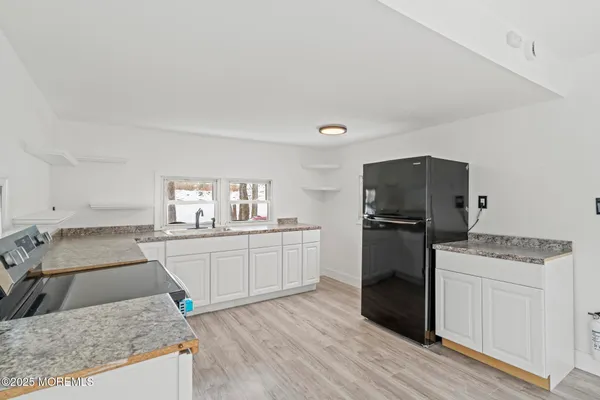 a kitchen with granite countertop a sink stove and refrigerator