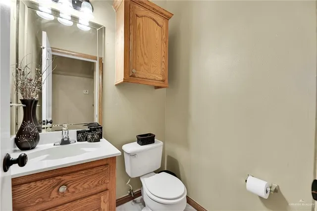 a bathroom with a sink vanity mirror and toilet