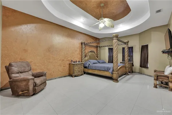 a spacious bedroom with a bed and a chandelier