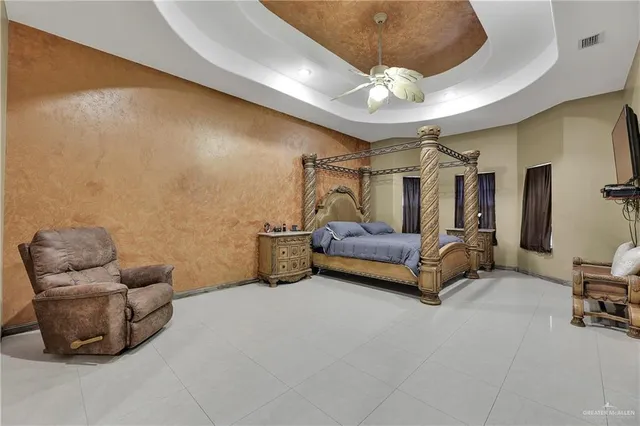 a spacious bedroom with a bed and a chandelier