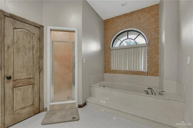 a bathroom with a granite countertop tub a sink and a mirror
