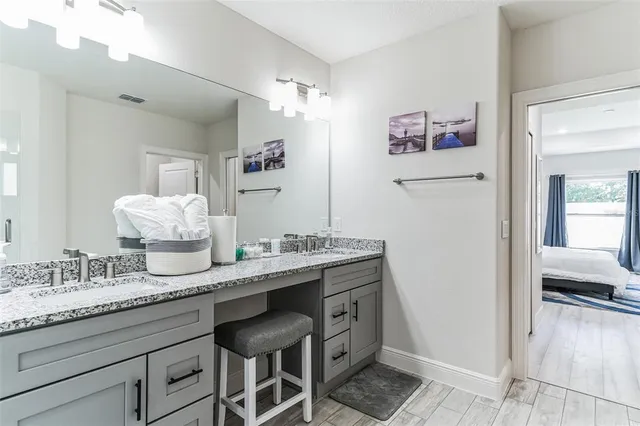 a en suite bathroom with a granite countertop sink and a mirror