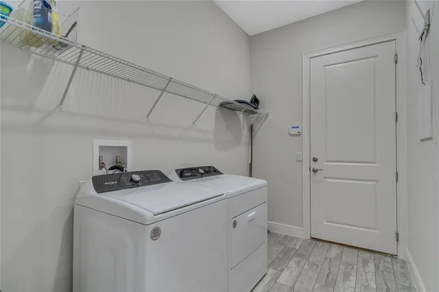 a utility room with dryer washer and empty racks