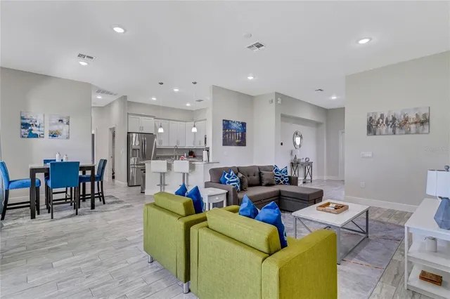 a living room with furniture and a dining table with wooden floor
